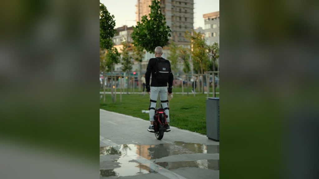 Adult riding an electric unicycle through a park