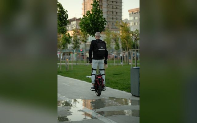 Adult riding an electric unicycle through a park