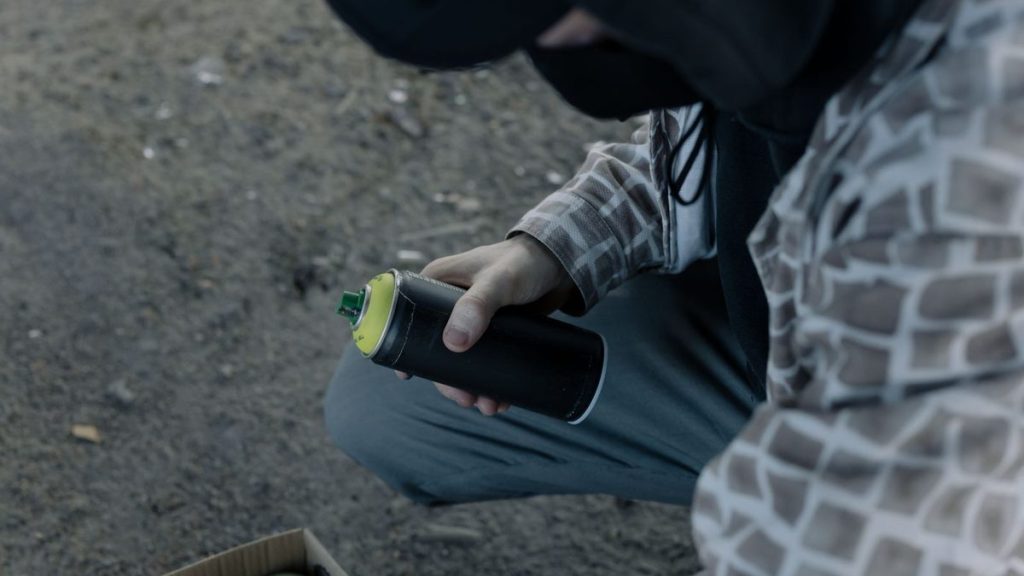 Artist holding a spray paint can outdoors