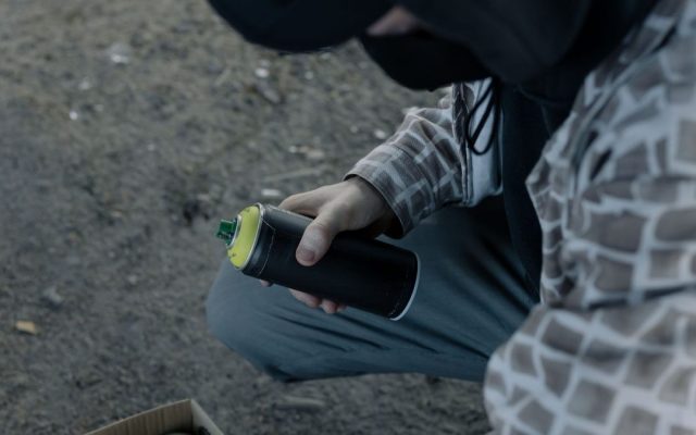 Artist holding a spray paint can outdoors