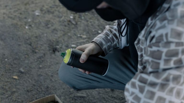Artist holding a spray paint can outdoors