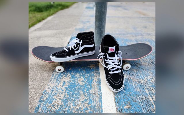 Black sneakers and a skateboard on concrete
