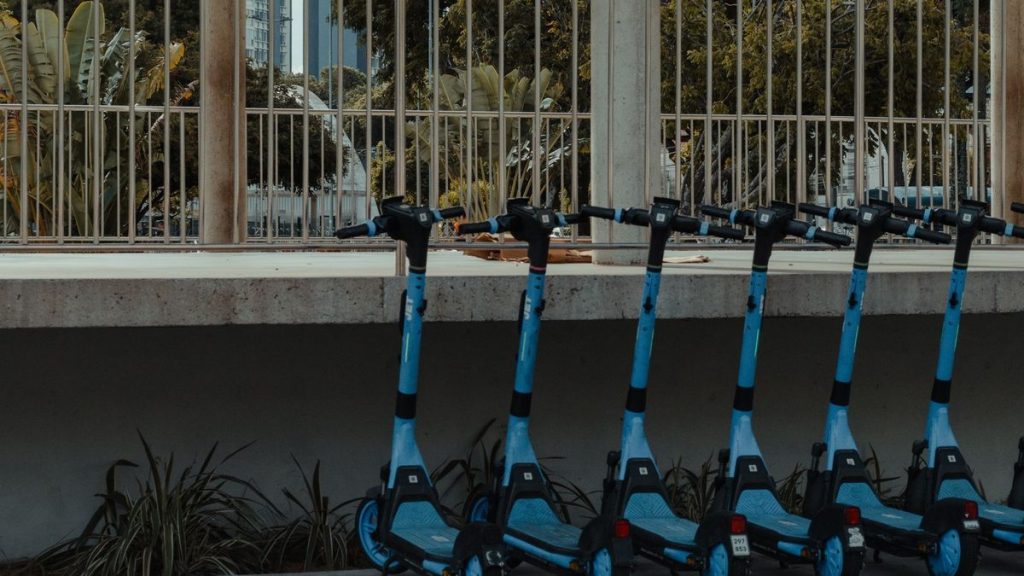 Blue electric scooters parked in a row