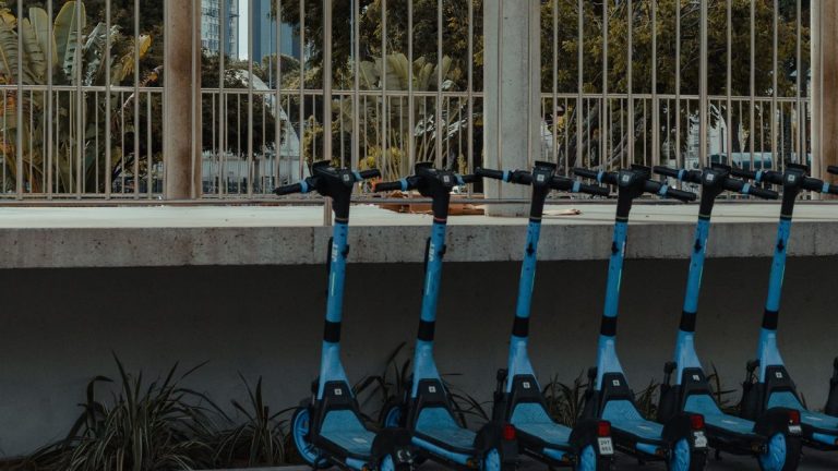 Blue electric scooters parked in a row