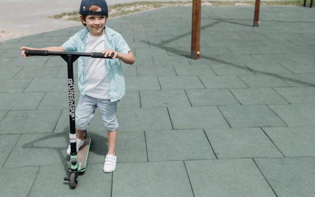 Boy riding a scooter in a park