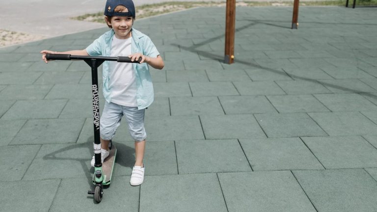 Boy riding a scooter in a park
