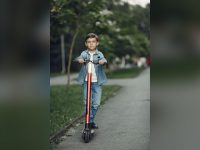 Boy riding a scooter in a park
