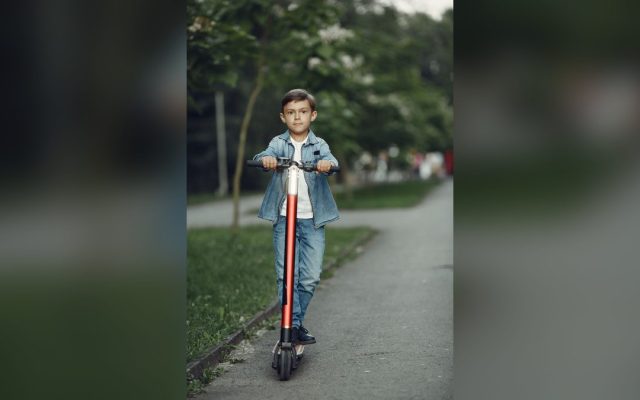Boy riding a scooter in a park