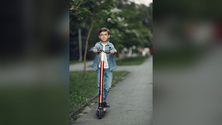 Boy riding a scooter in a park