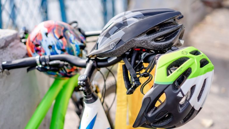 Brightly coloured bicycle helmets on handlebars