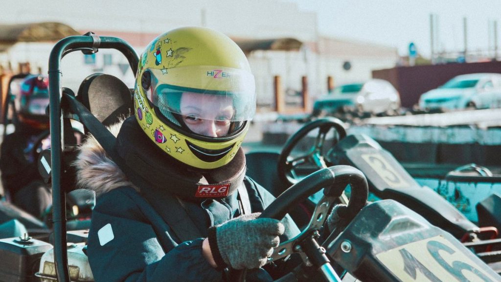 Child in a helmet ready to race a go-kart