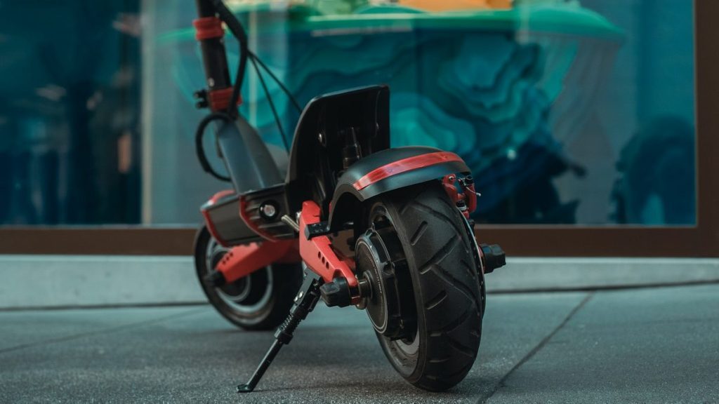 Close-up of a dual-motor electric scooter's rear wheel and suspension