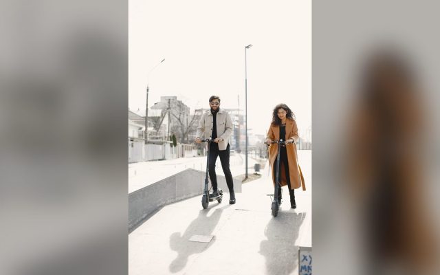 Couple riding e-scooters through a modern city