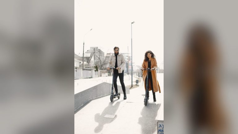 Couple riding e-scooters through a modern city