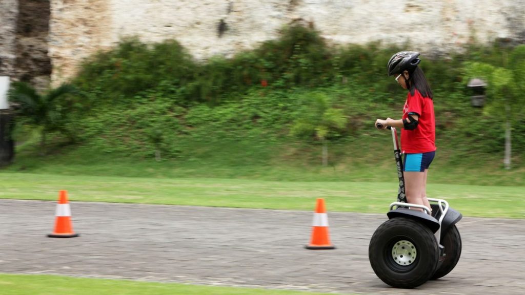 Girl in safety gear riding a self-balancing scooter