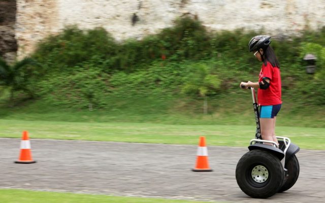 Girl in safety gear riding a self-balancing scooter