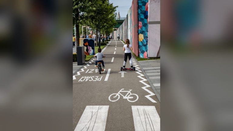 Girl on a self-balancing board and boy on a bicycle in the city