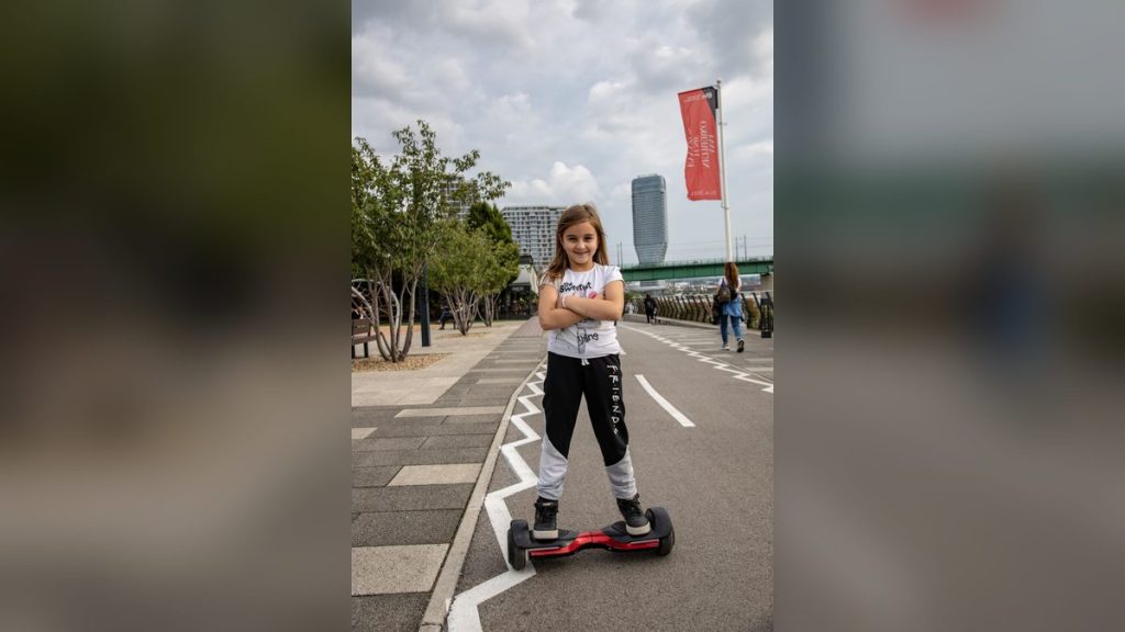 Girl riding a hoverboard on a city promenade