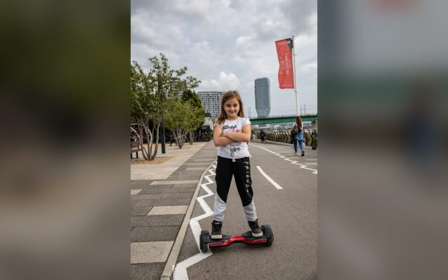 Girl riding a hoverboard on a city promenade