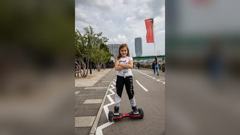 Girl riding a hoverboard on a city promenade