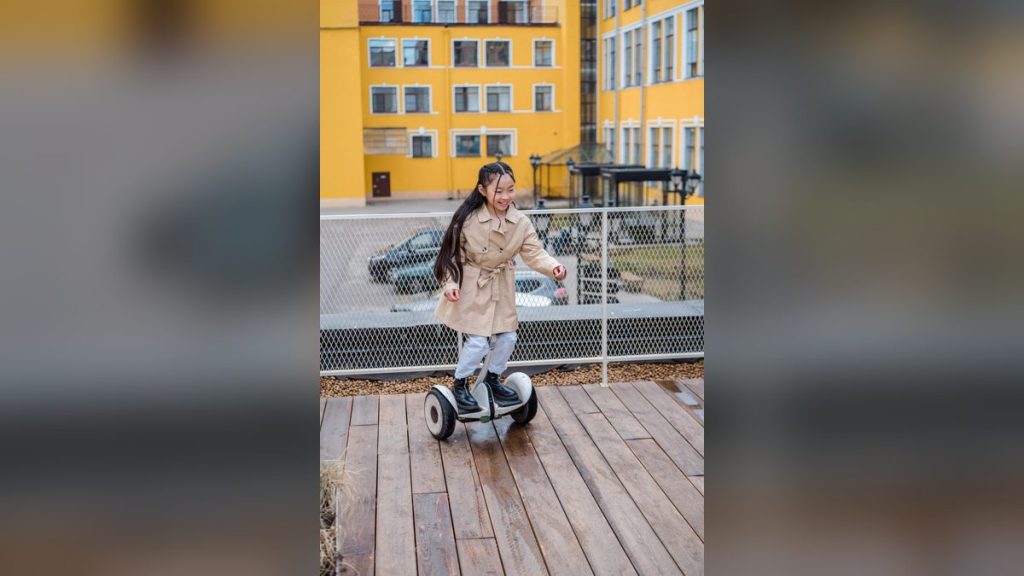 Girl riding a hoverboard on a wooden deck