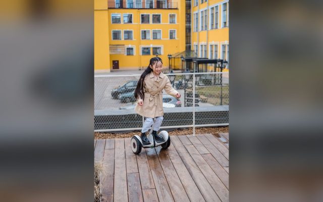 Girl riding a hoverboard on a wooden deck