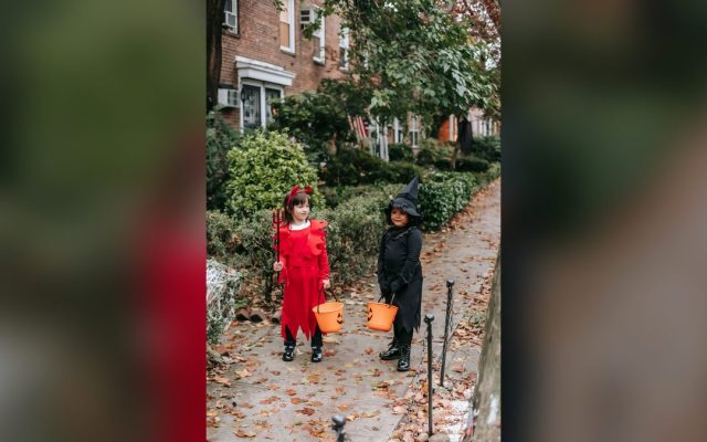Girls in witch and devil costumes trick-or-treating