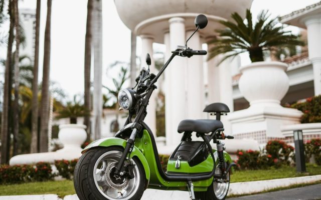 Green electric moped parked in the city