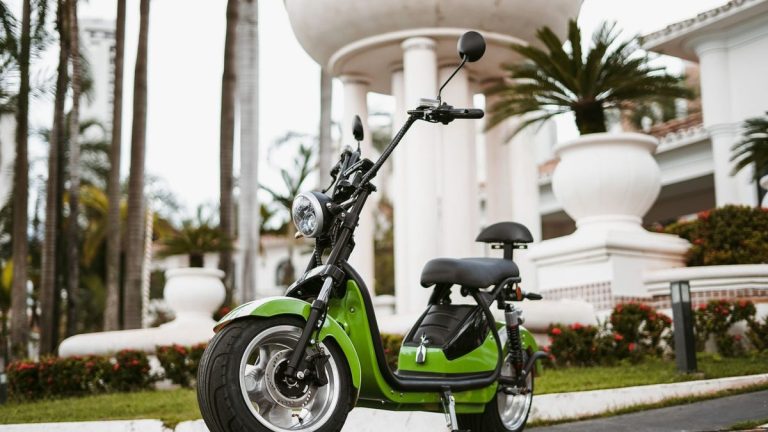 Green electric moped parked in the city