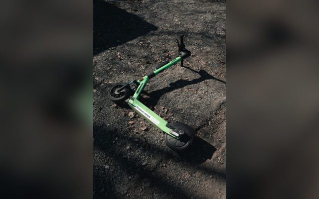 Green electric scooter on a gravel path