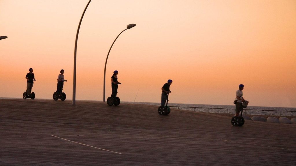 Group riding self-balancing scooters at sunset