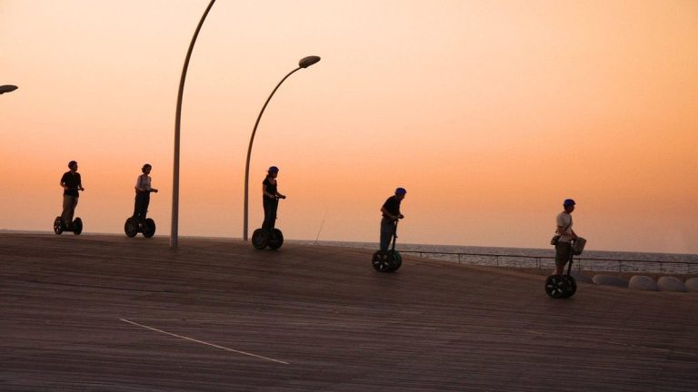 Group riding self-balancing scooters at sunset
