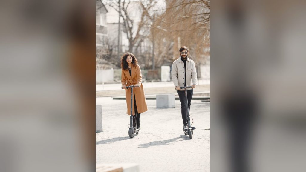 Happy couple riding e-scooters on a sunny day