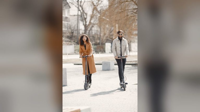 Happy couple riding e-scooters on a sunny day