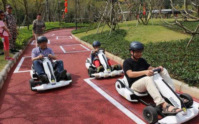 Kids riding hoverboard go-karts on a sunny day