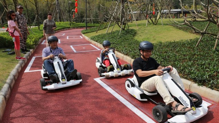 Kids riding hoverboard go-karts on a sunny day