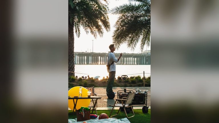 Man on a self-balancing scooter at the waterfront at sunset