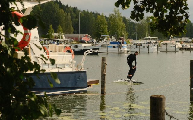 Man riding a hoverboard beside a marina