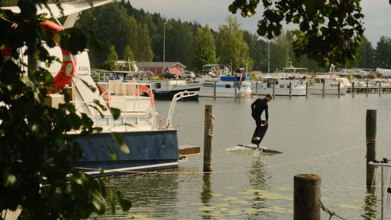 Man riding a hoverboard beside a marina