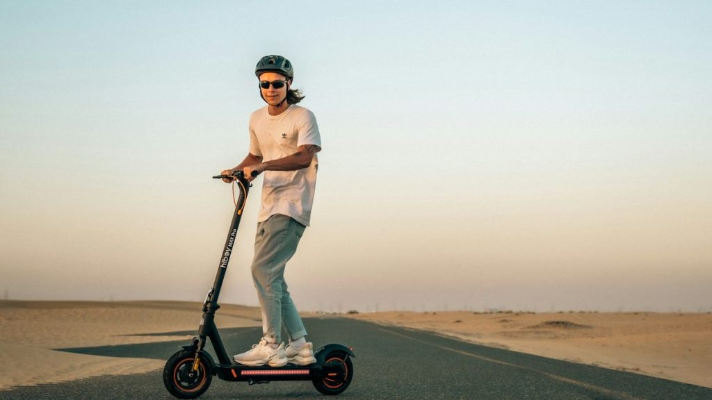 Man riding an electric scooter across the desert