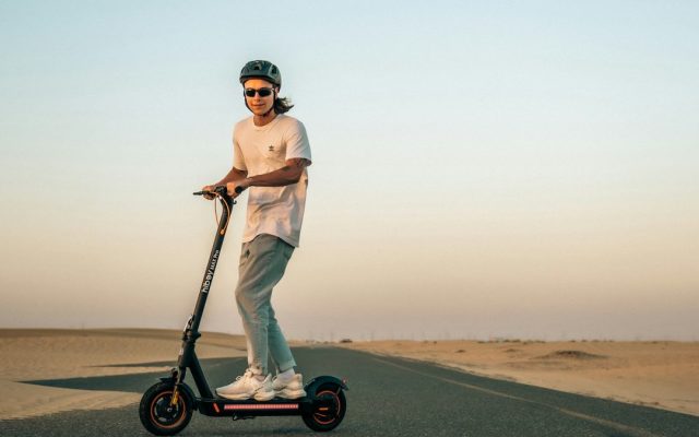 Man riding an electric scooter across the desert