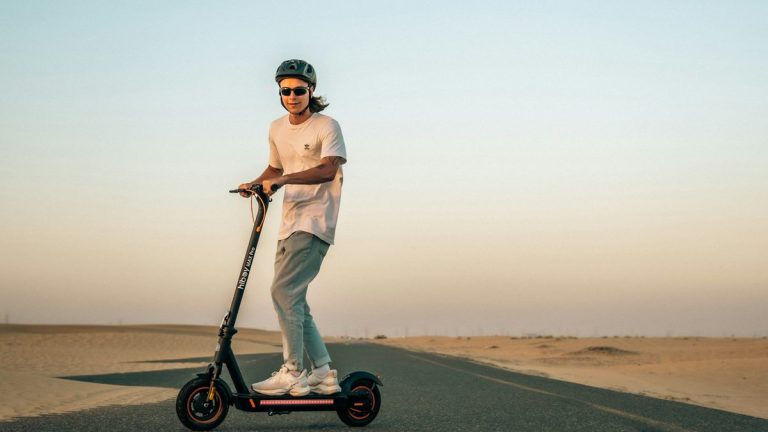 Man riding an electric scooter across the desert