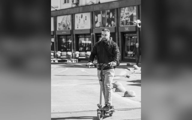 Man riding an electric scooter on a city street