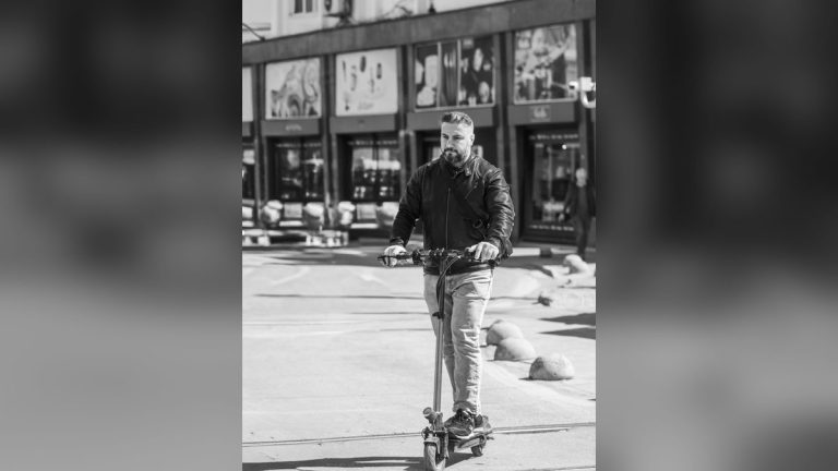 Man riding an electric scooter on a city street
