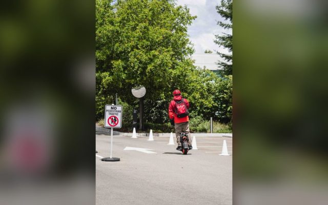 Man riding an electric unicycle near a tech campus