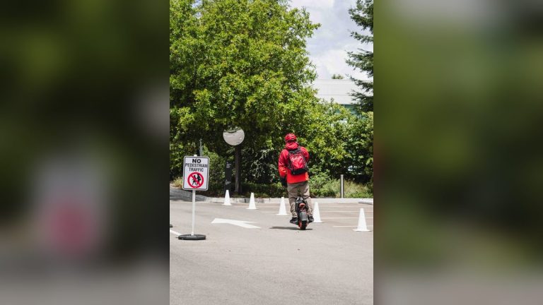 Man riding an electric unicycle near a tech campus