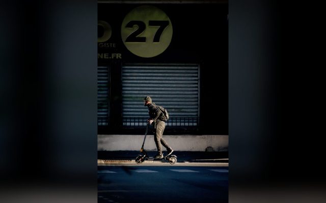 Man with a backpack riding an electric scooter
