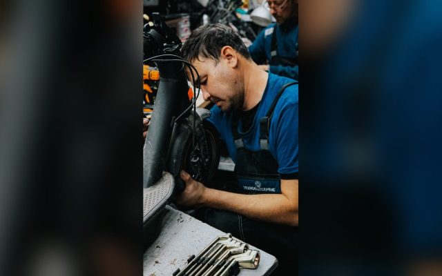 Mechanic repairing an electric scooter in a workshop