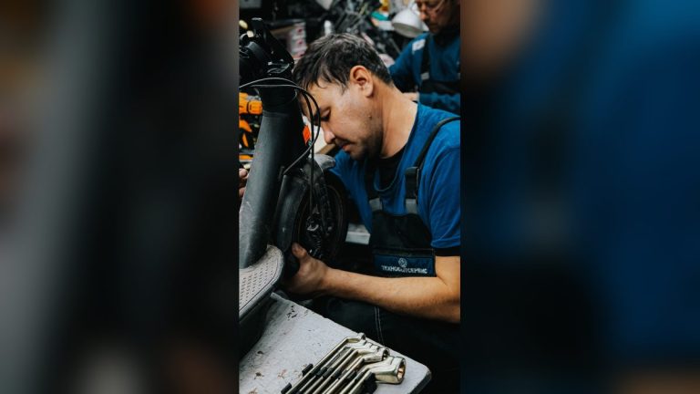 Mechanic repairing an electric scooter in a workshop