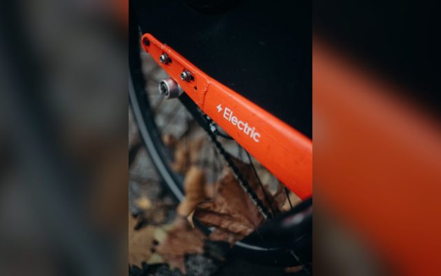 Orange electric bicycle among autumn leaves